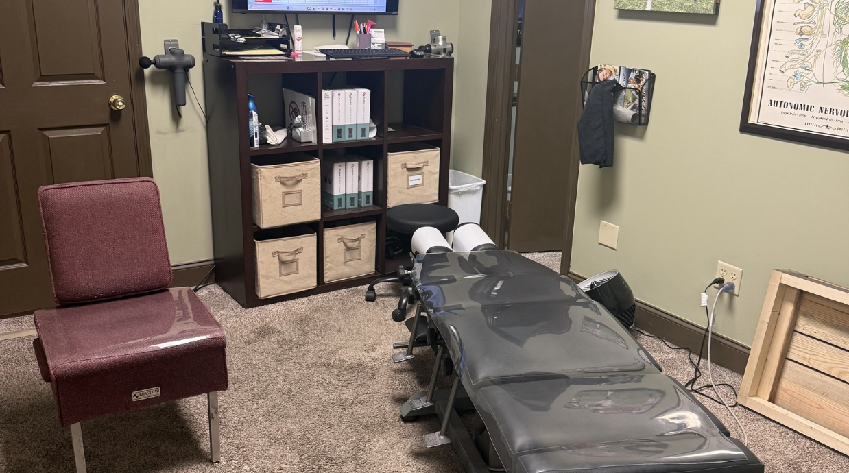 Interior view of a McCracken Chiropractic examination room featuring a patient adjustment table.